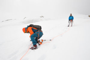 Descent from the Bishorn summit, mountaineers on a steep slope Descent from the Bishorn summit, mountaineers on a steep slope